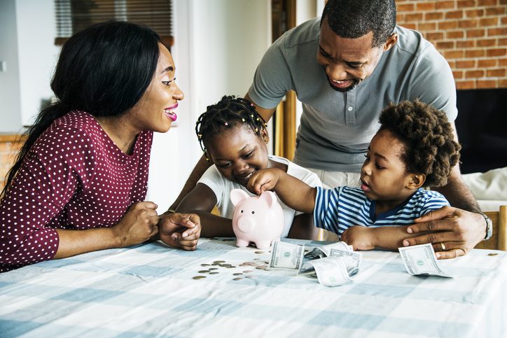 Family adding money to piggy bank