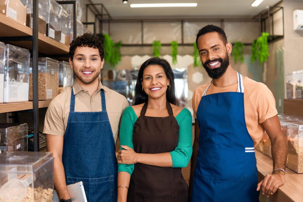 Group of employees look at camera and smile in grocery store