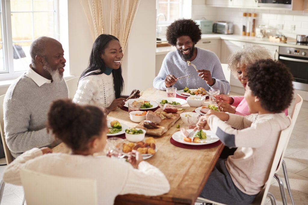 Multi generation mixed race family eating their Sunday dinner